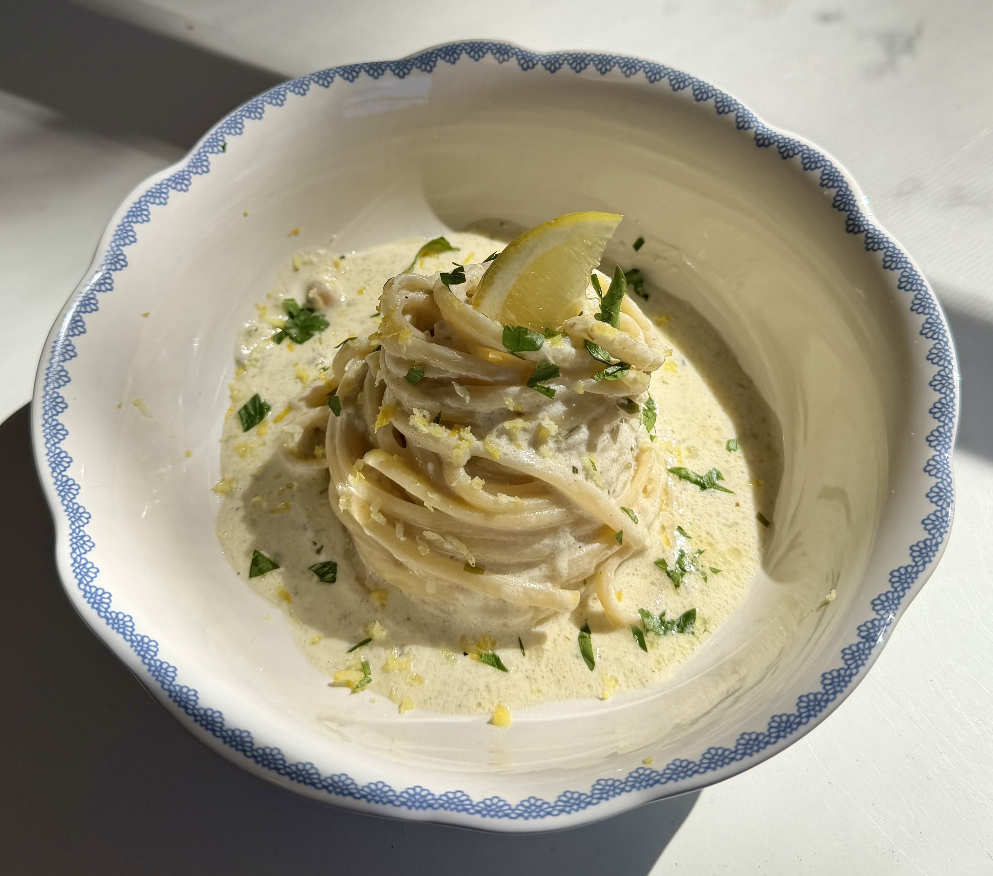 Creamy lemon herb pasta, finished with fresh lemon and herbs